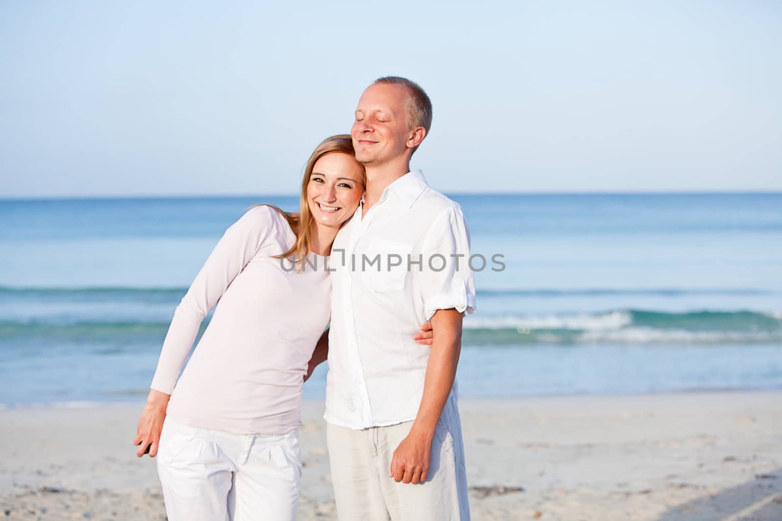 happy young couple in love having fun on the beach blue sky and sunshine 