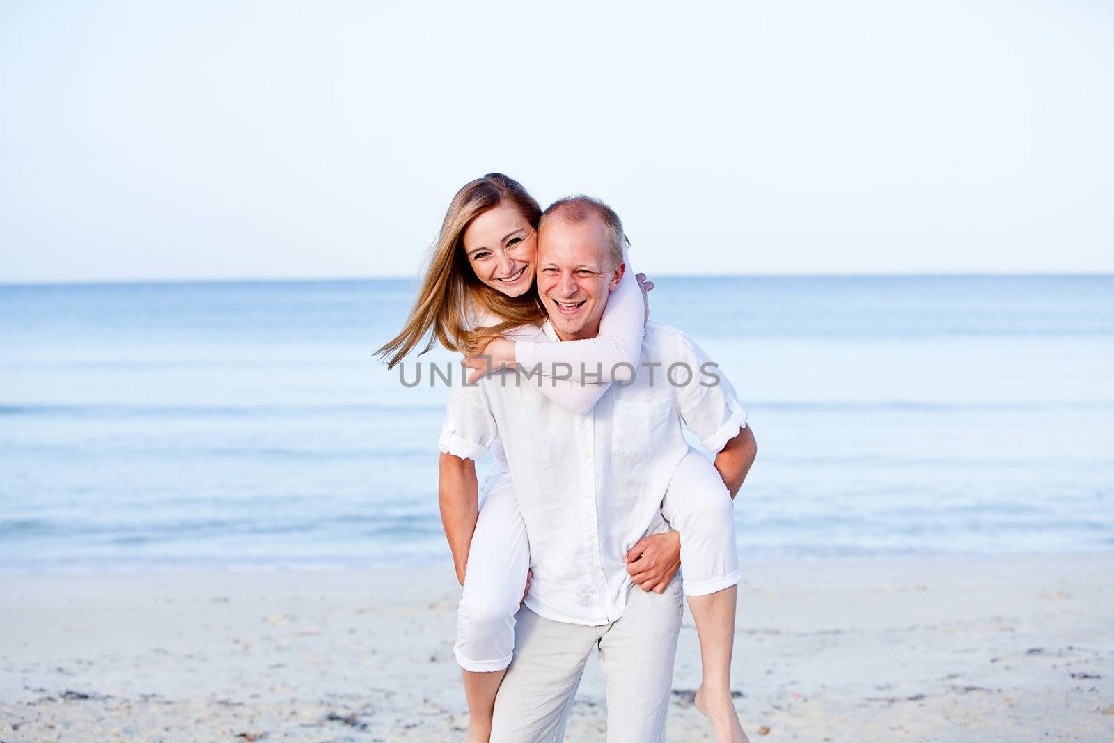 happy young couple in love having fun on the beach blue sky and sunshine 