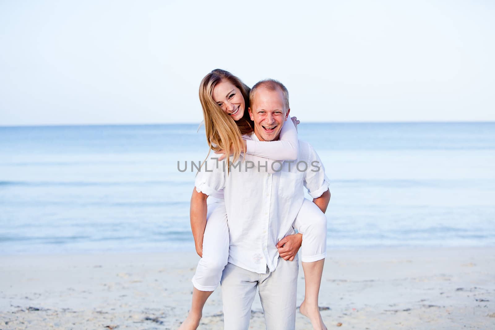 happy young couple in love having fun on the beach blue sky and sunshine 