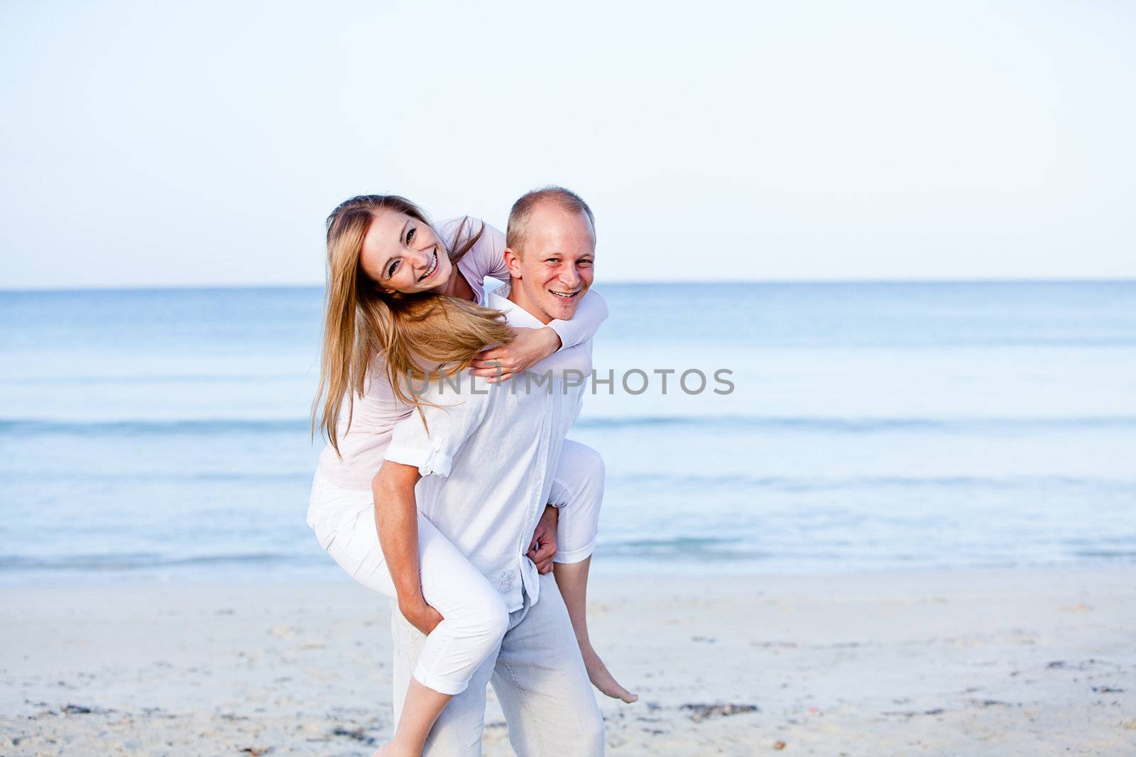 happy young couple in love having fun on the beach blue sky and sunshine 