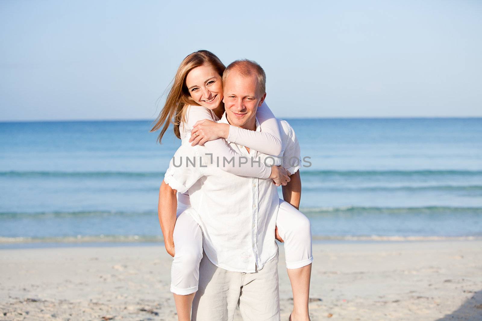 happy young couple in love having fun on the beach blue sky and sunshine 