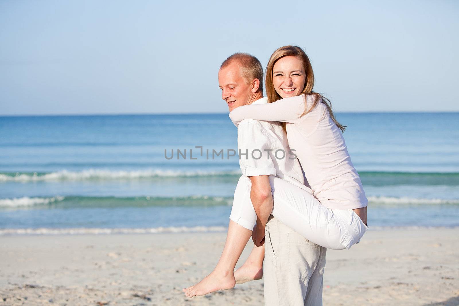 happy young couple in love having fun on the beach blue sky and sunshine 