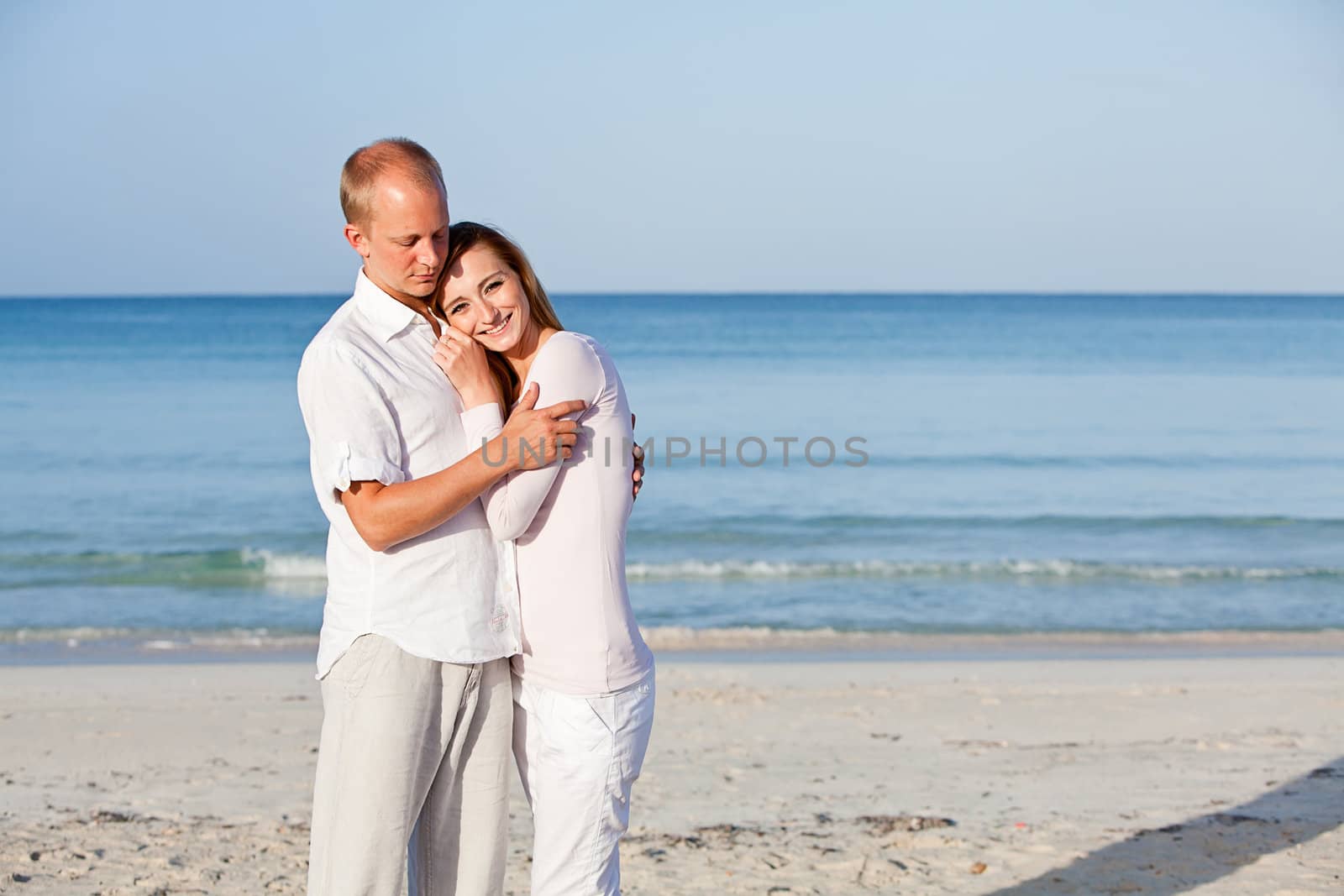 happy young couple in love having fun on the beach blue sky and sunshine 