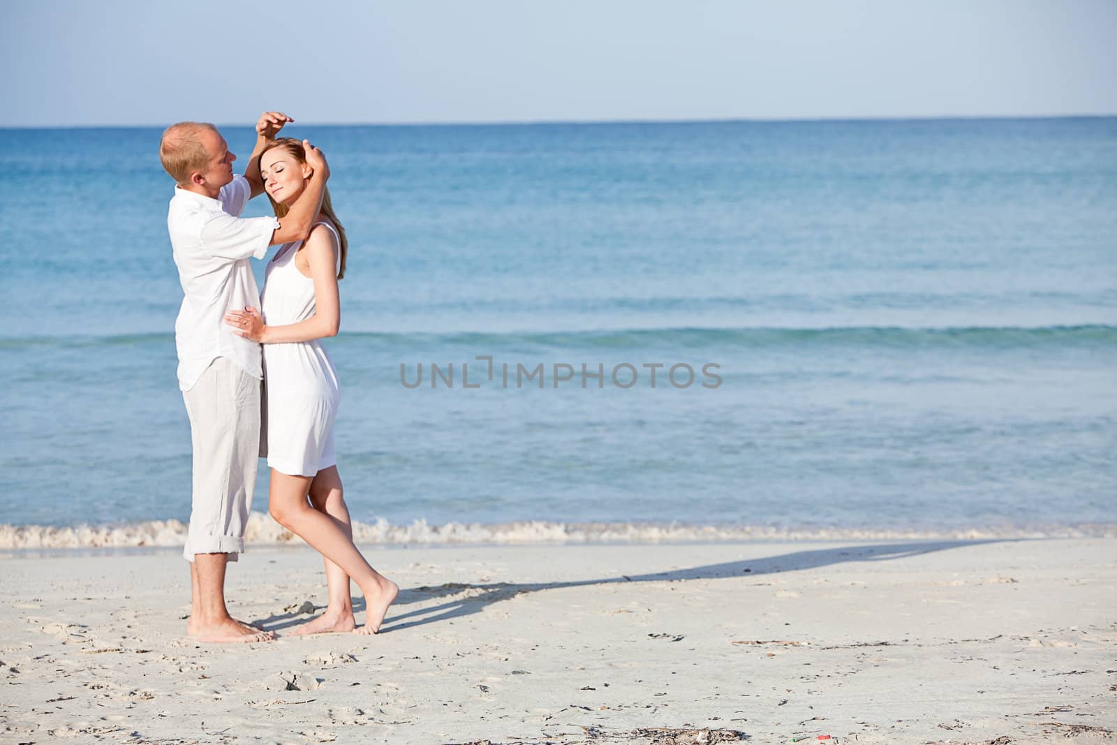 happy young couple in love having fun on the beach blue sky and sunshine 