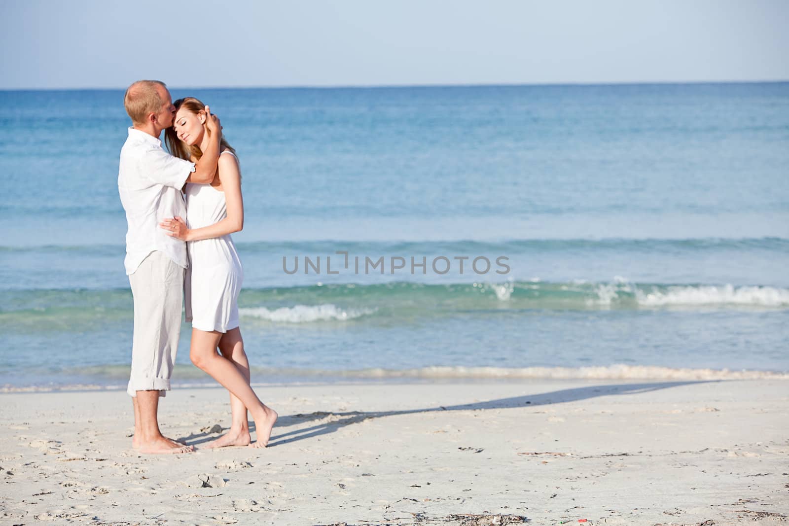 happy young couple in love having fun on the beach blue sky and sunshine 