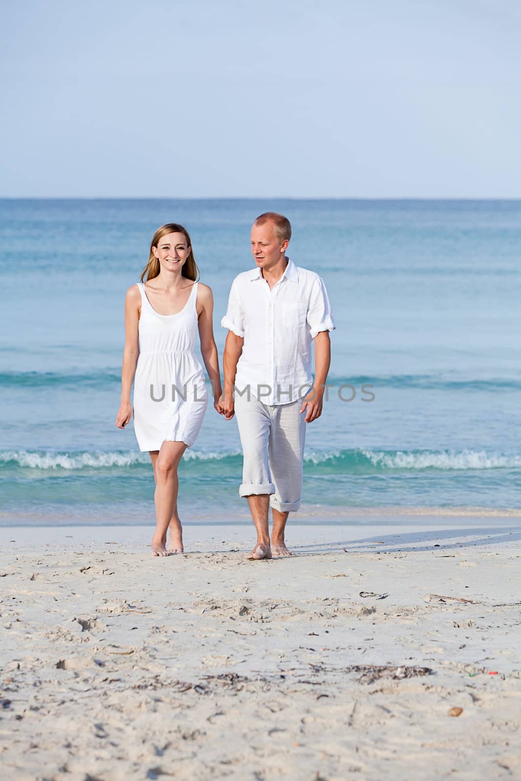 happy young couple in love having fun on the beach blue sky and sunshine 