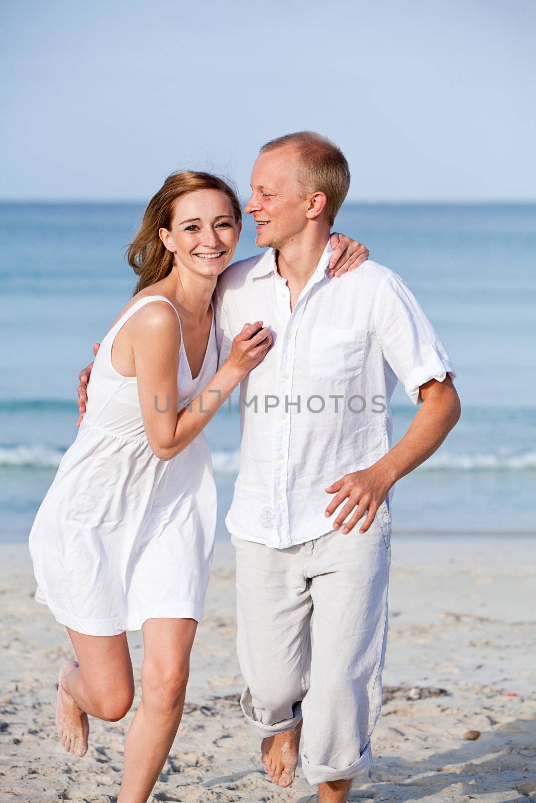 happy young couple in love having fun on the beach blue sky and sunshine 