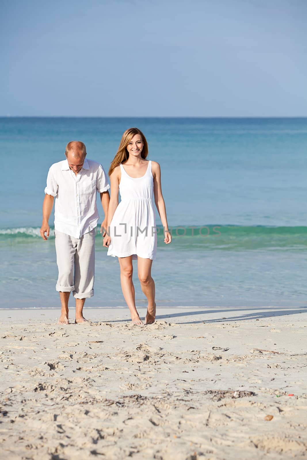 happy young couple in love having fun on the beach blue sky and sunshine 