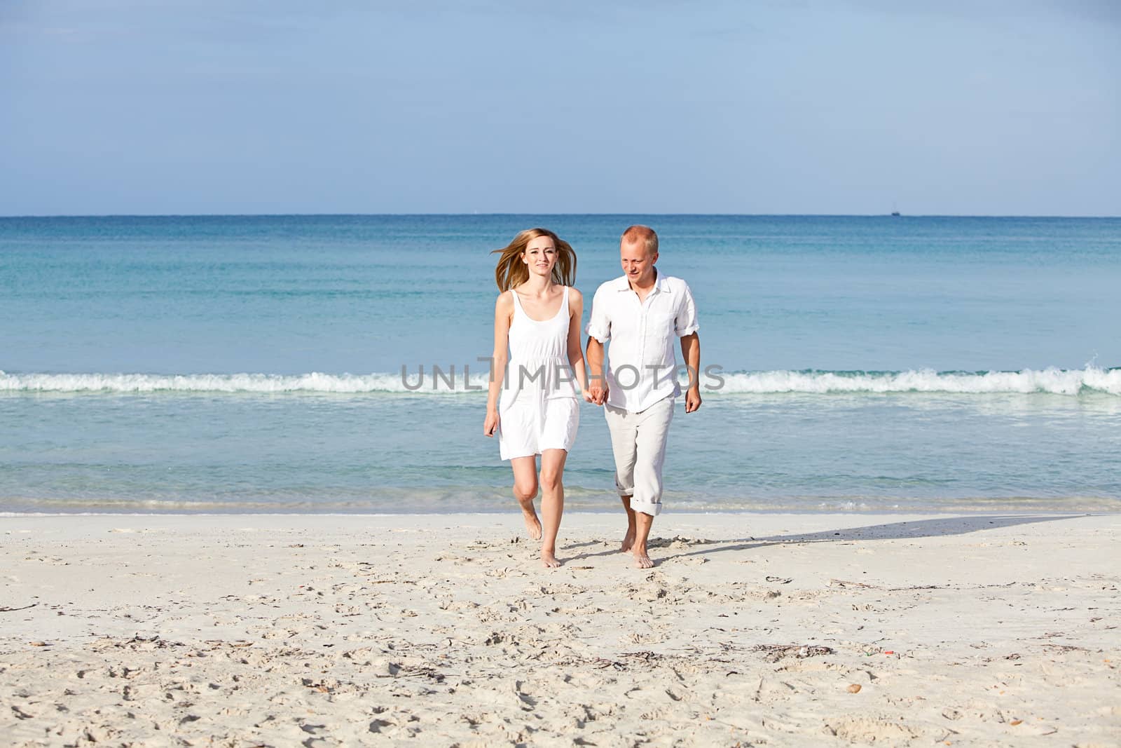 happy young couple in love having fun on the beach blue sky and sunshine 