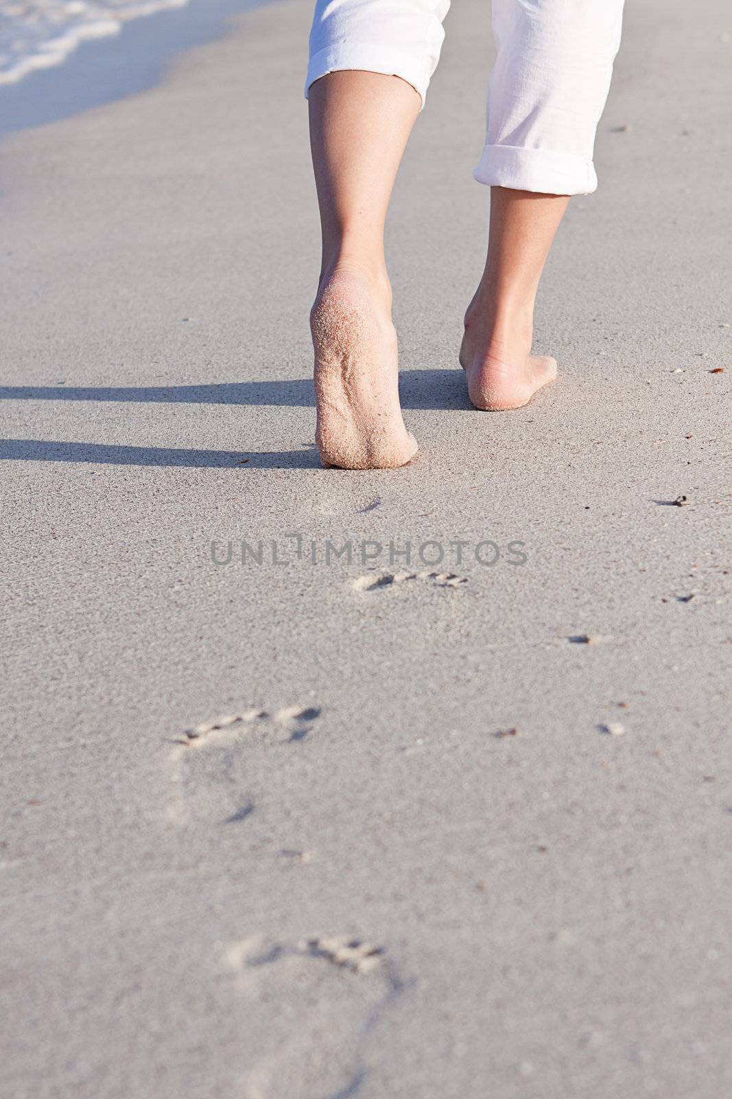 walking barefoot in the sand in summer holidays on beach