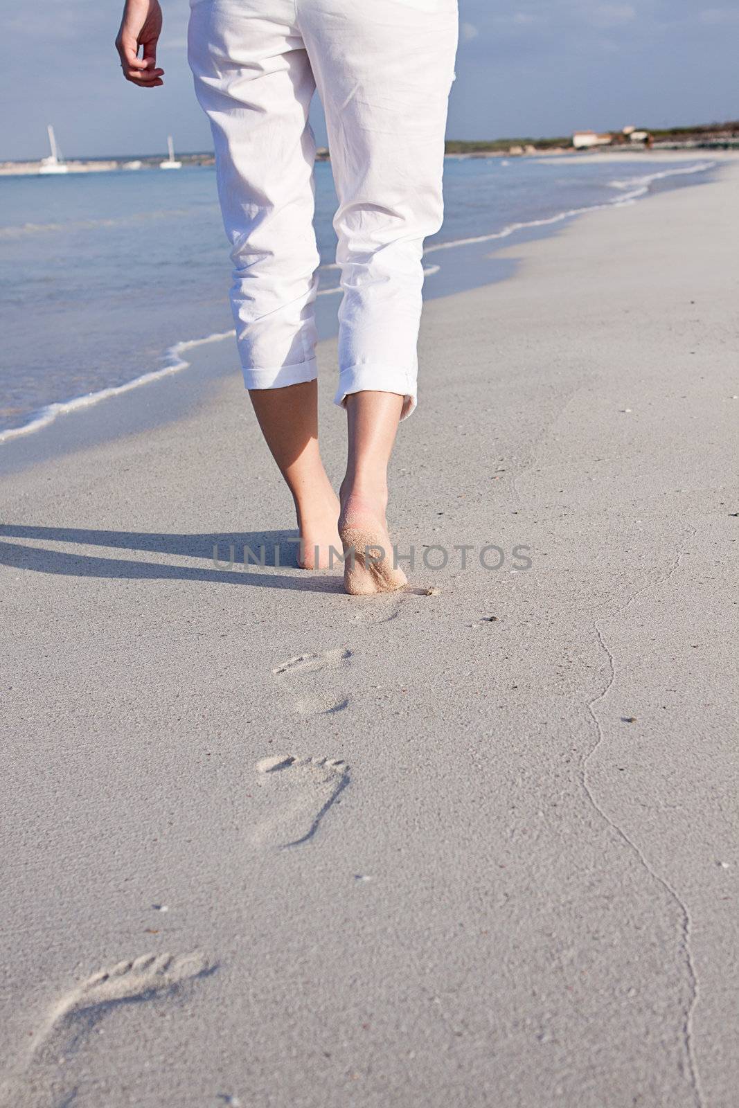 walking barefoot in the sand in summer holidays on beach