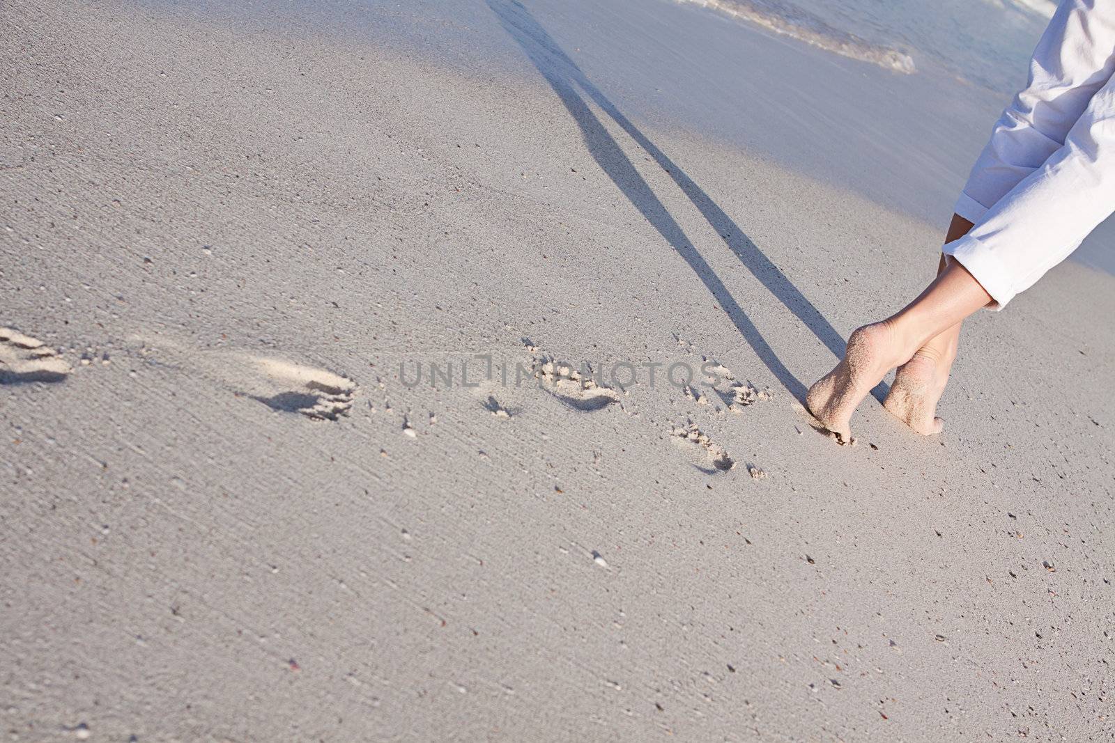 walking barefoot in the sand in summer holidays on beach