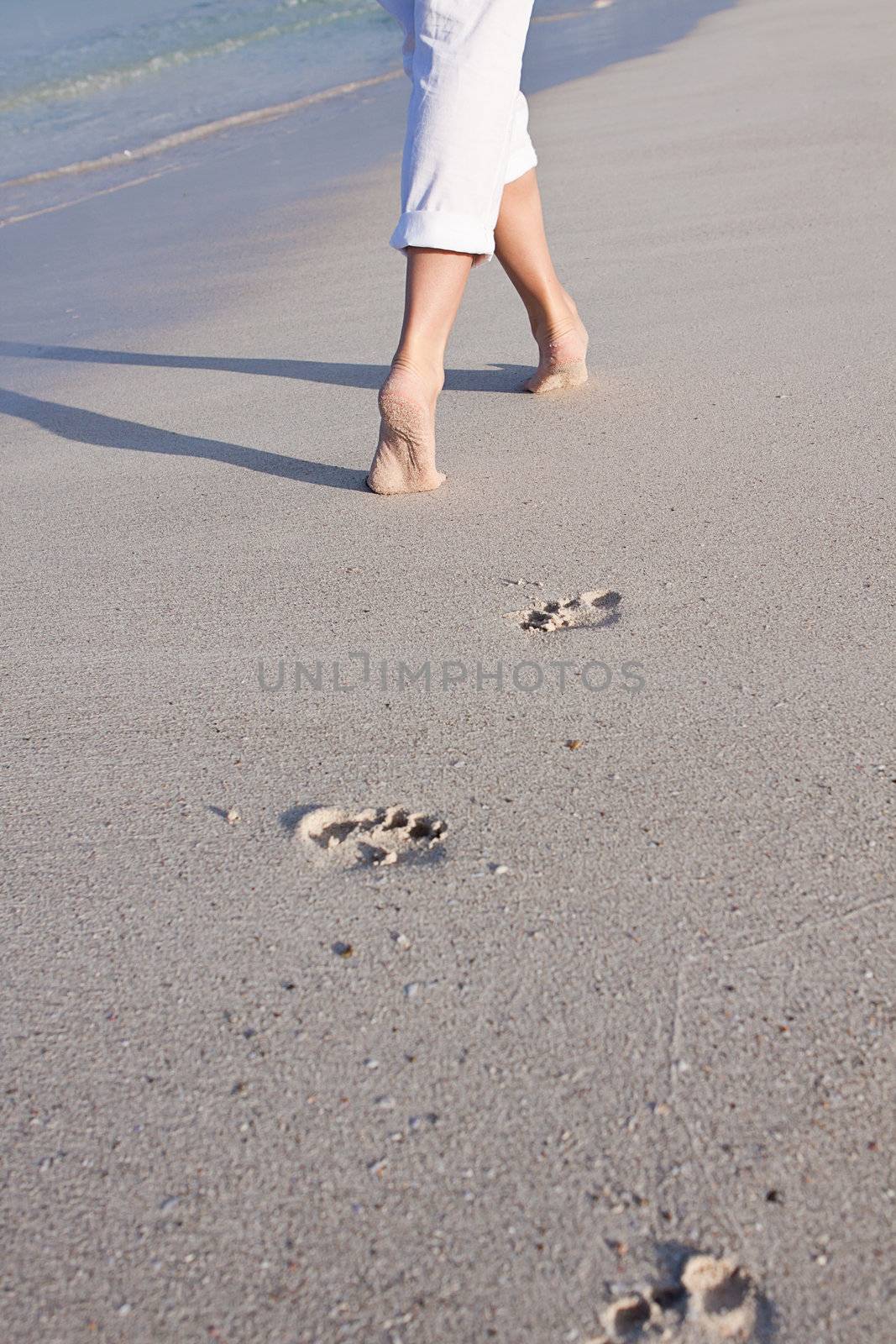 walking barefoot in the sand in summer holidays on beach