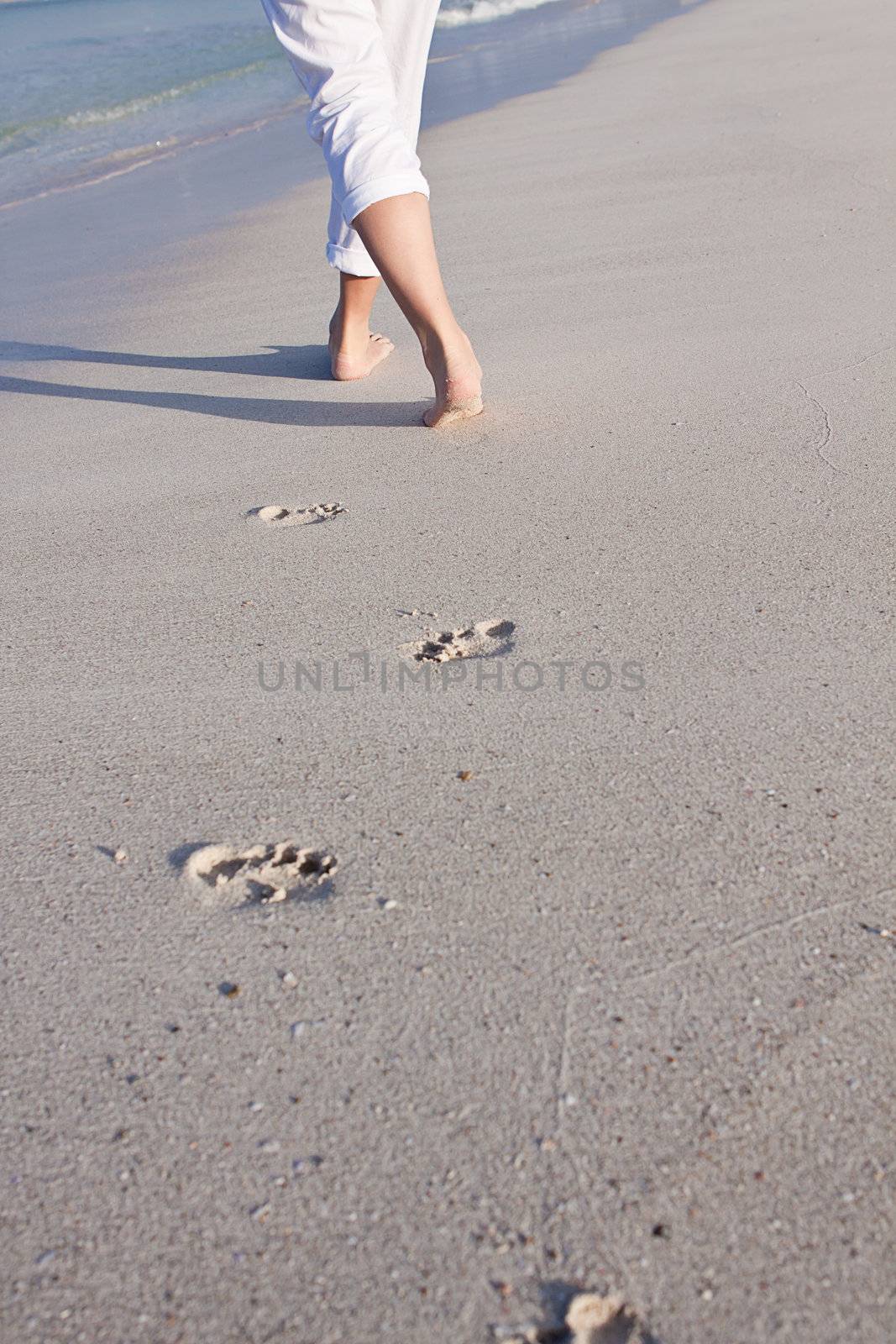 walking barefoot in the sand in summer holidays on beach
