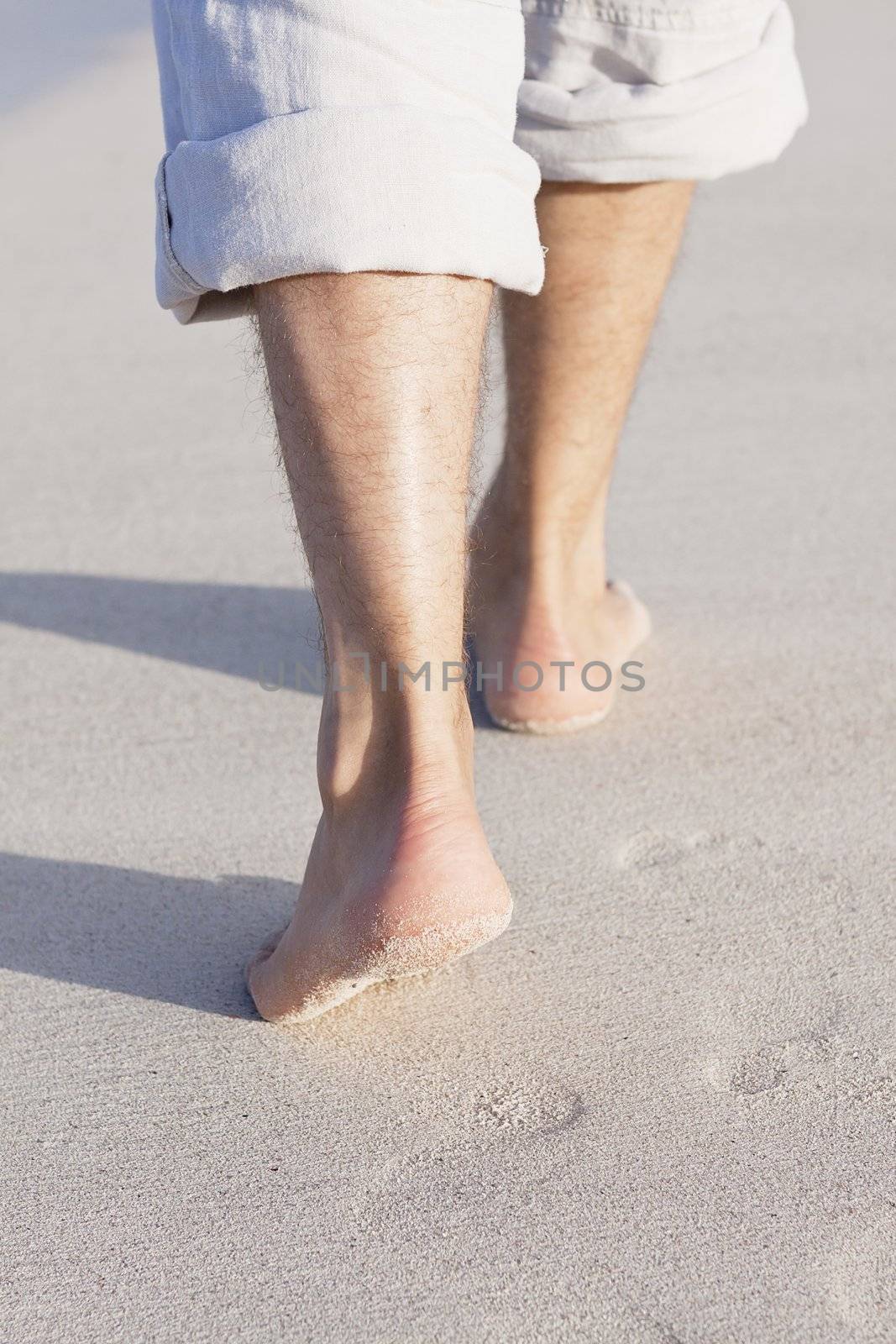 walking barefoot in the sand in summer holidays on beach