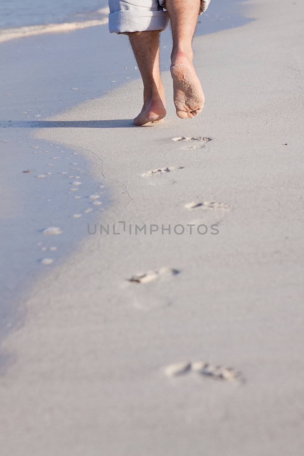 walking barefoot in the sand in summer holidays on beach