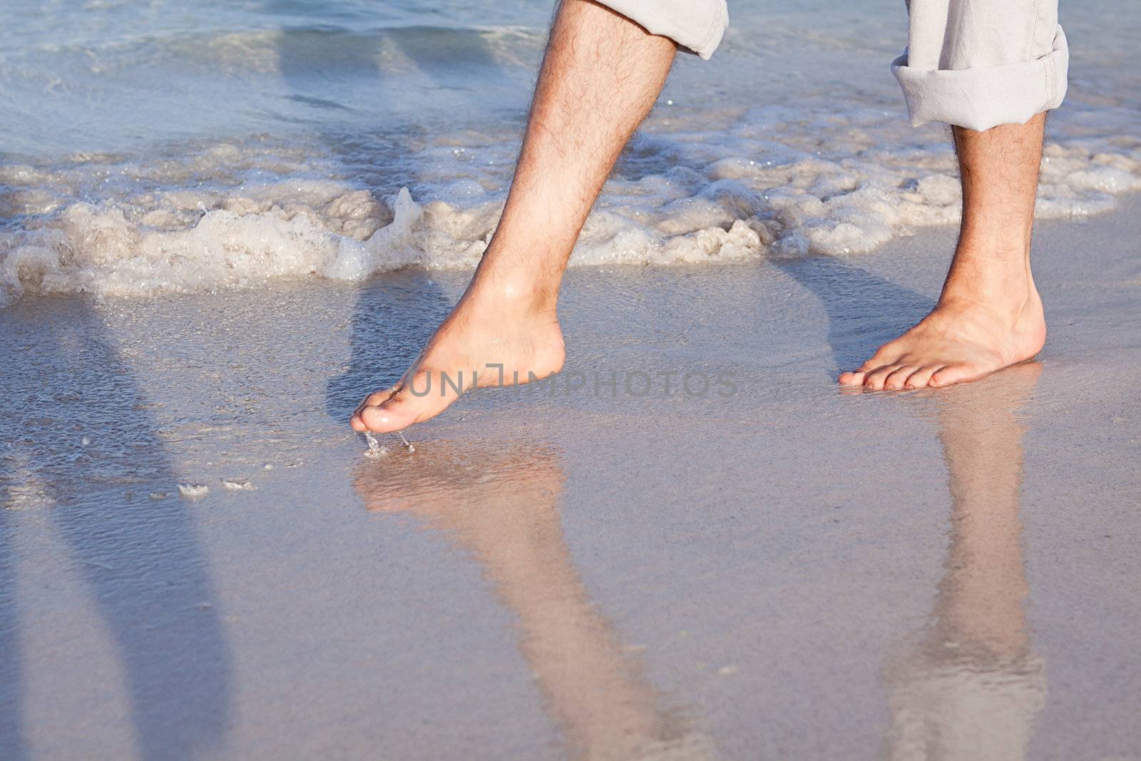 walking barefoot in the sand in summer holidays on beach