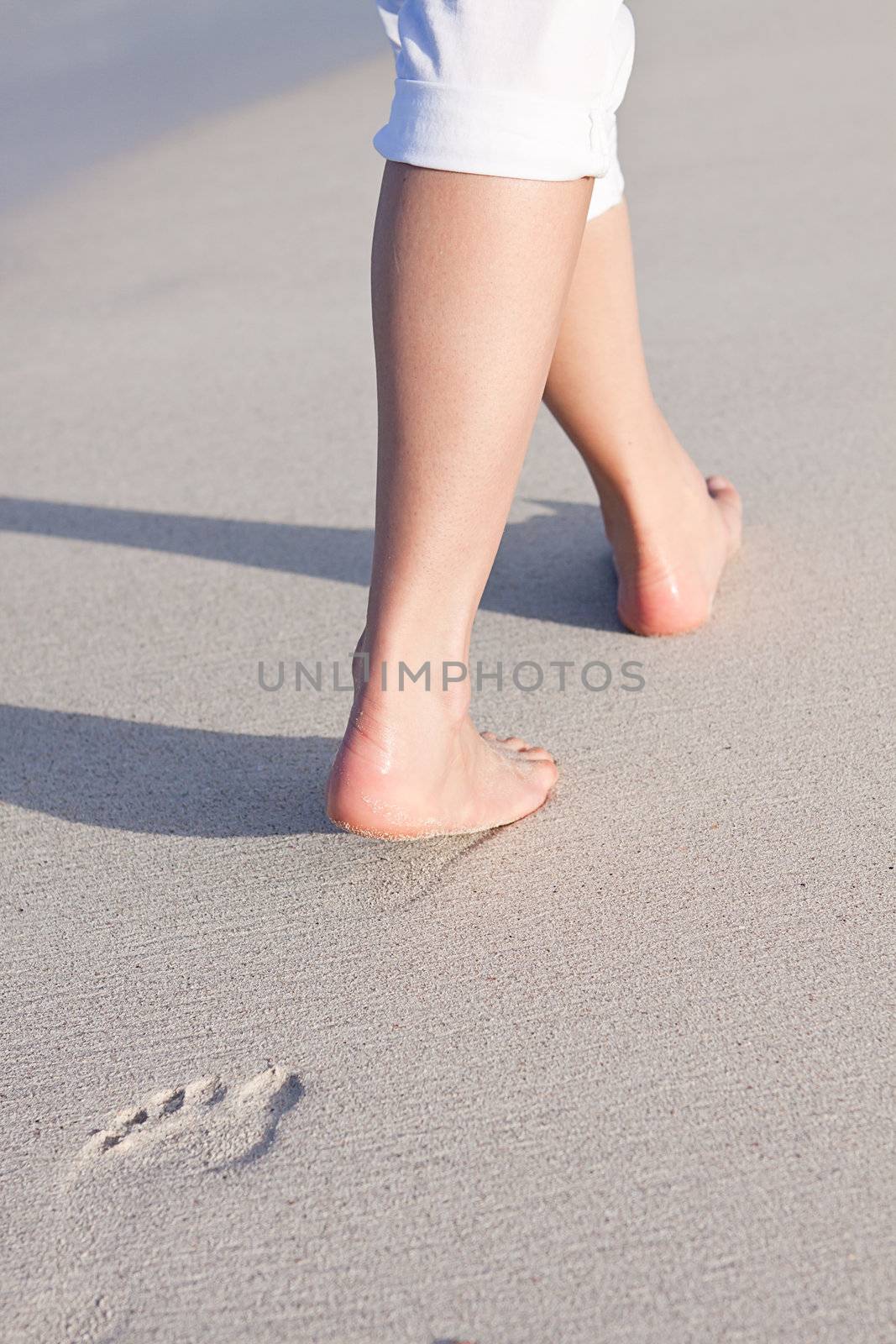 walking barefoot in the sand in summer holidays on beach