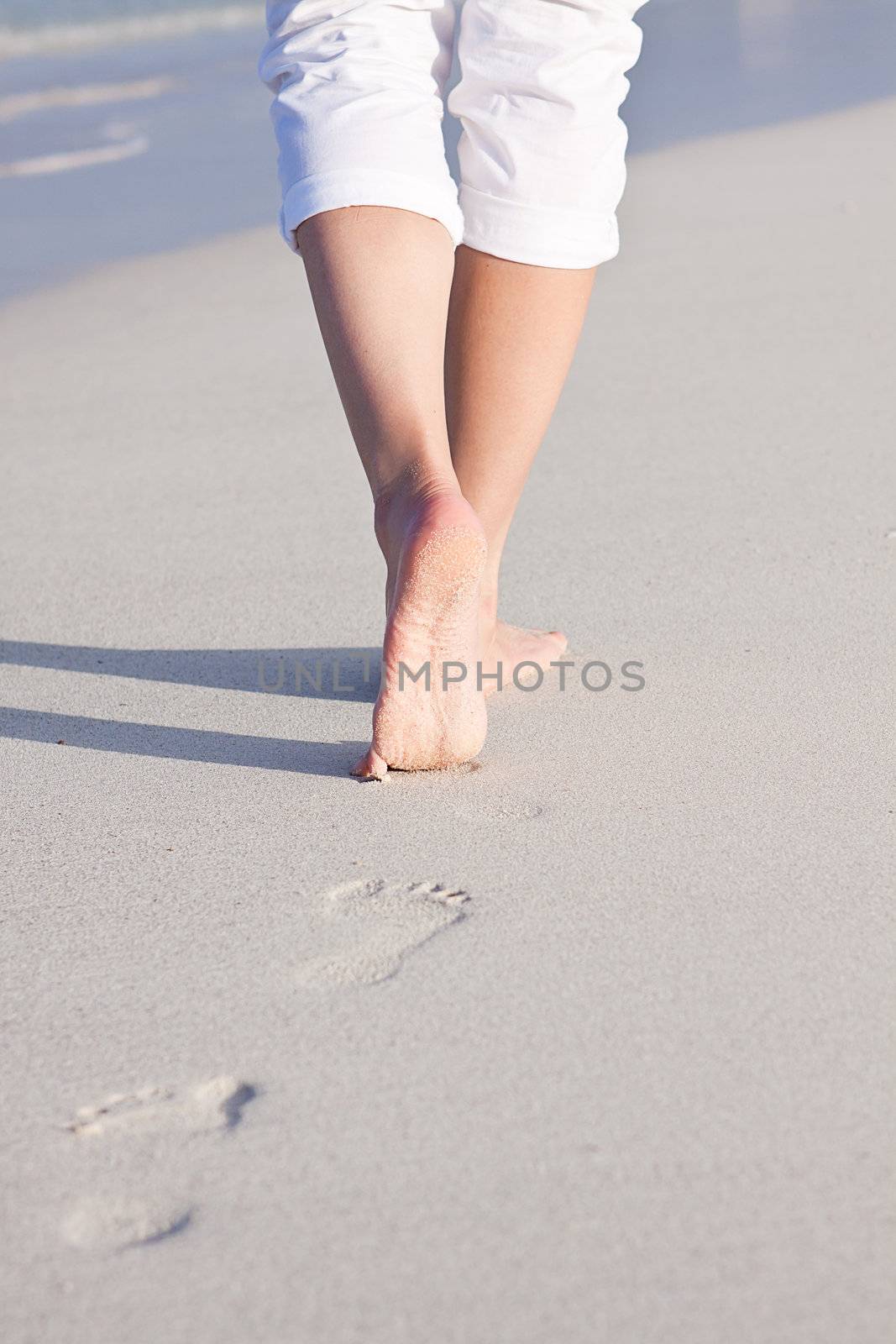 walking barefoot in the sand in summer holidays on beach