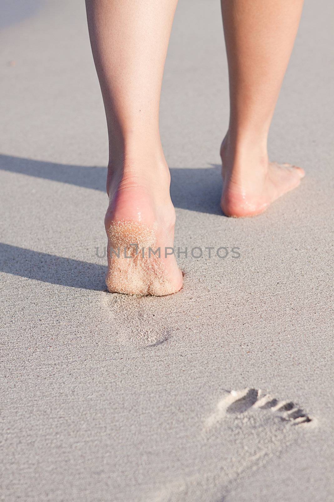 walking barefoot in the sand in summer holidays on beach
