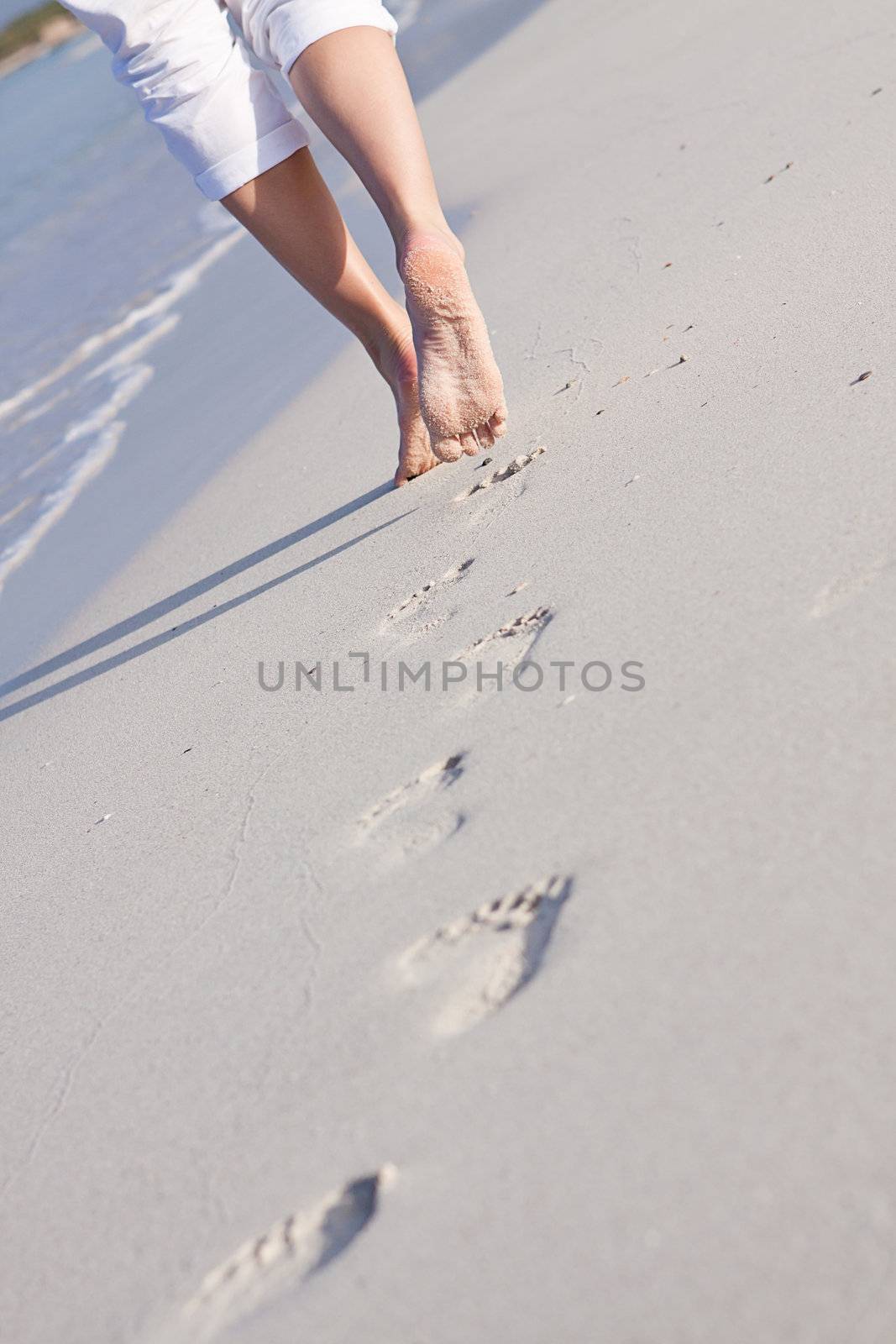 walking barefoot in the sand in summer holidays on beach