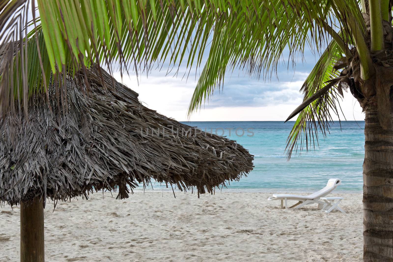 A single beach chair along the shore on a tropical resort.