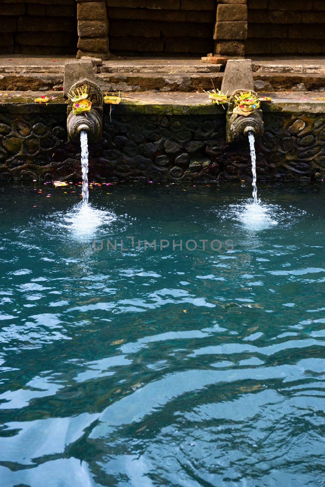 Fountains and pool with holy spring water in Tirta Empul temple, Bali, Indonesia 