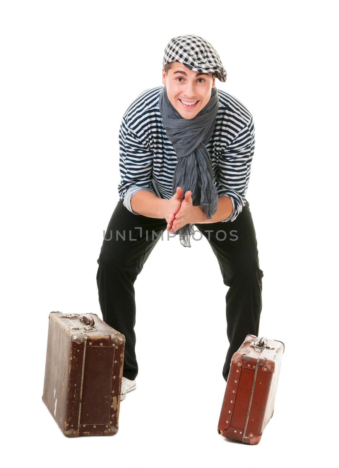Happy lucky young male traveller with two old vintage suitcases rubs his hands isolated on white background