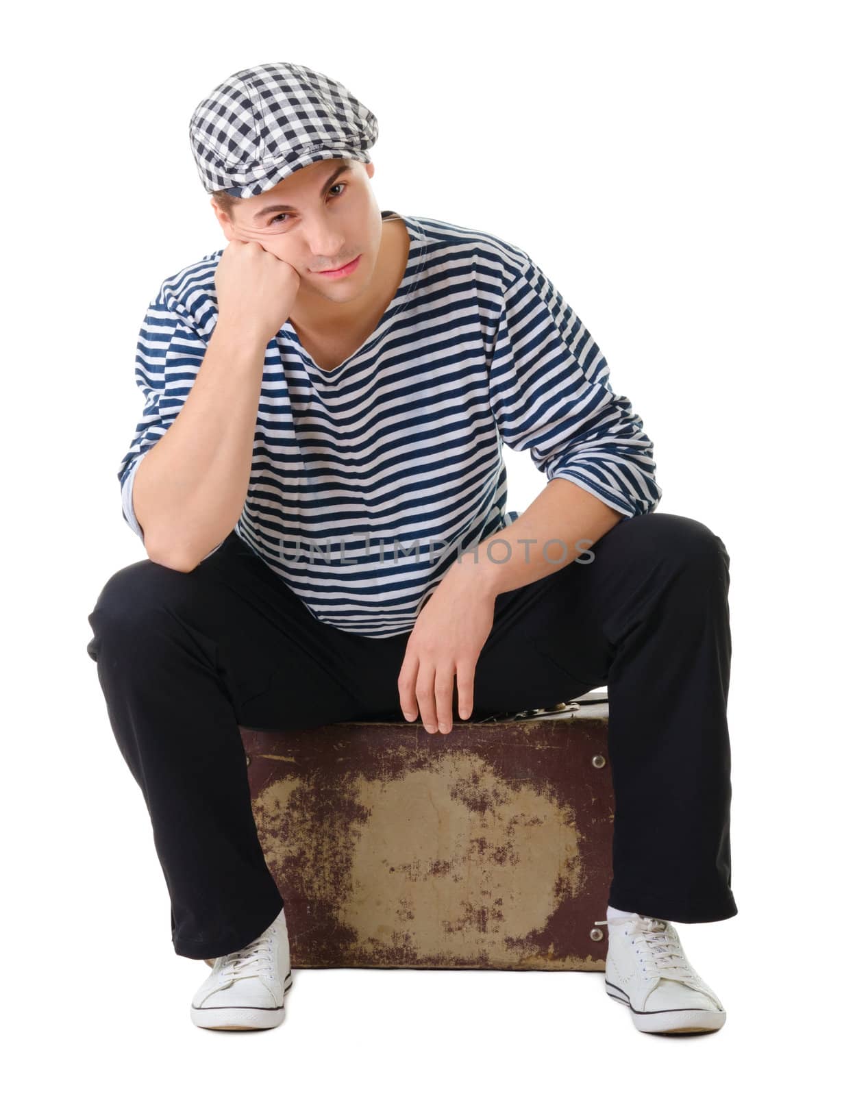 Sad waiting young male traveler siting on old vintage suitcase isolated on white background