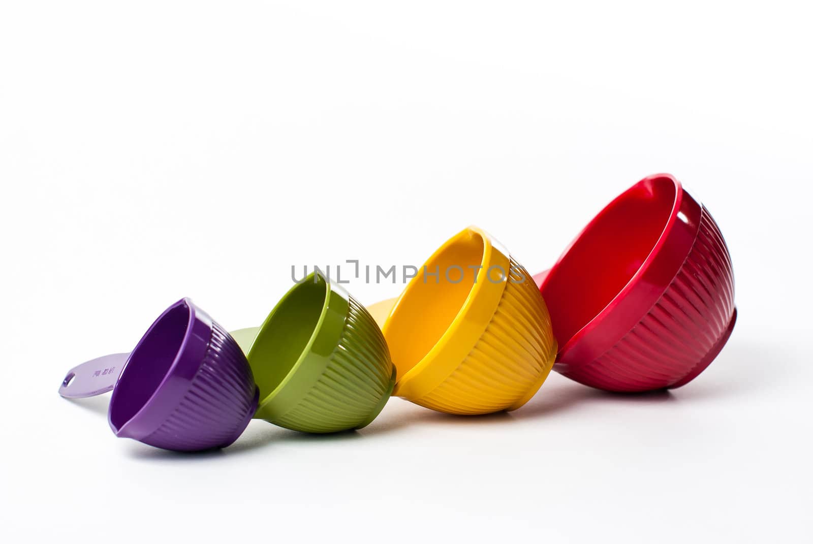 Colorful Measuring Cups in Increasing Size on White by oliverjw