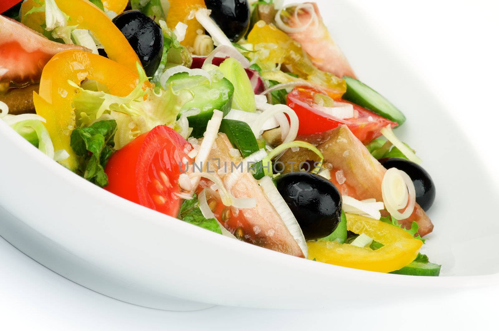 Vegetable Salad with Tomatoes, Yellow Bell Pepper, Leek, Black Olive, Cucumber, Lettuce and Olive Oil in White Bowl closeup