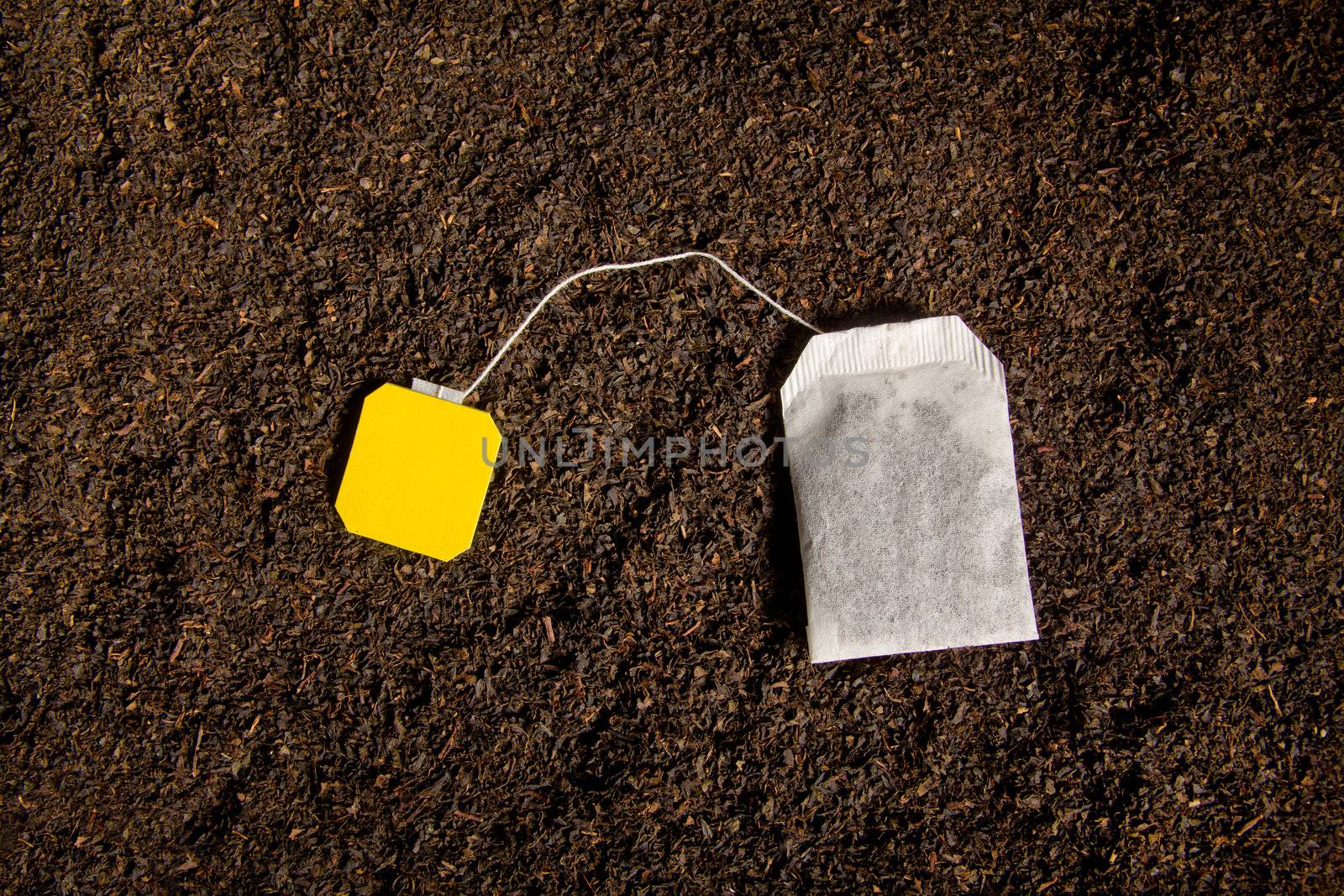 Tea bag with blank label on dried tea leafs