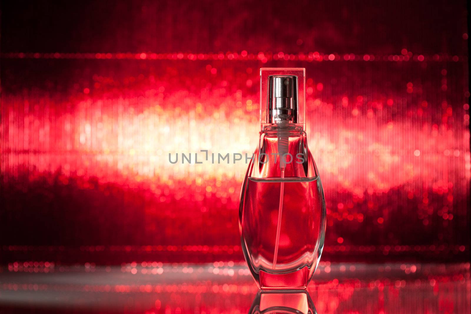 Bottle of perfume on red background by Speedskater