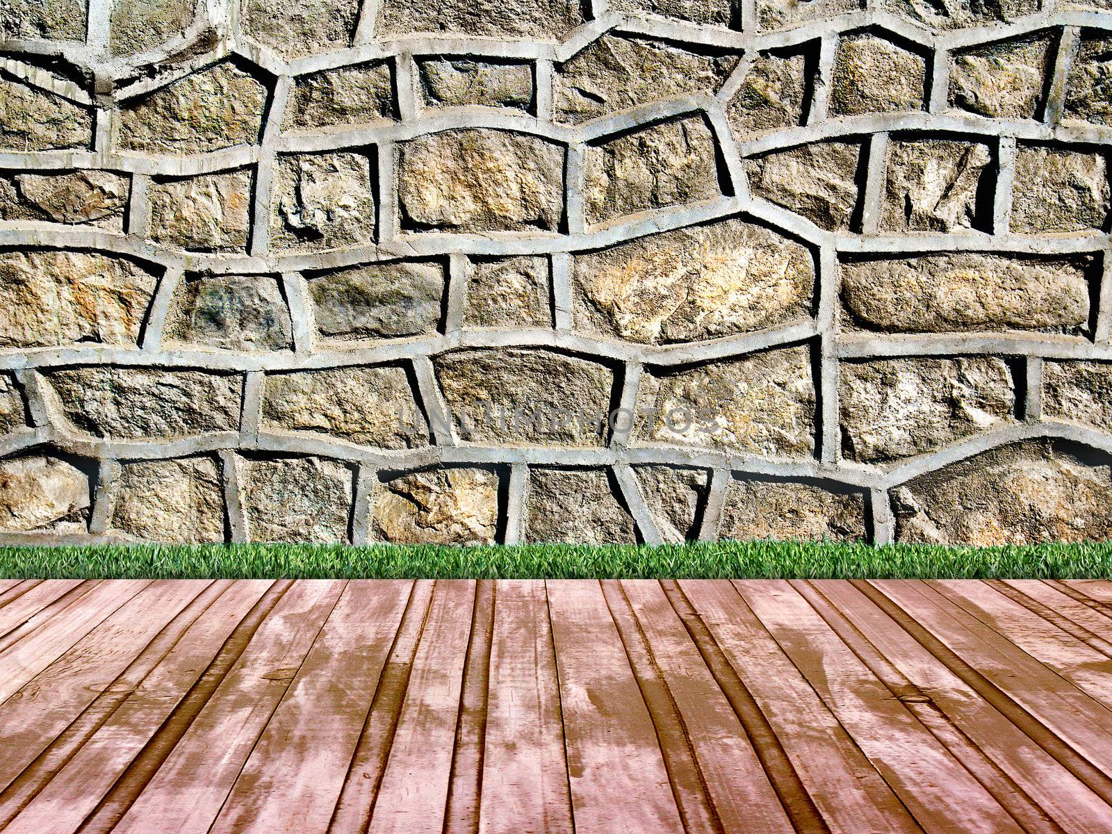 room with a stone wall overgrown with grass and wooden floors