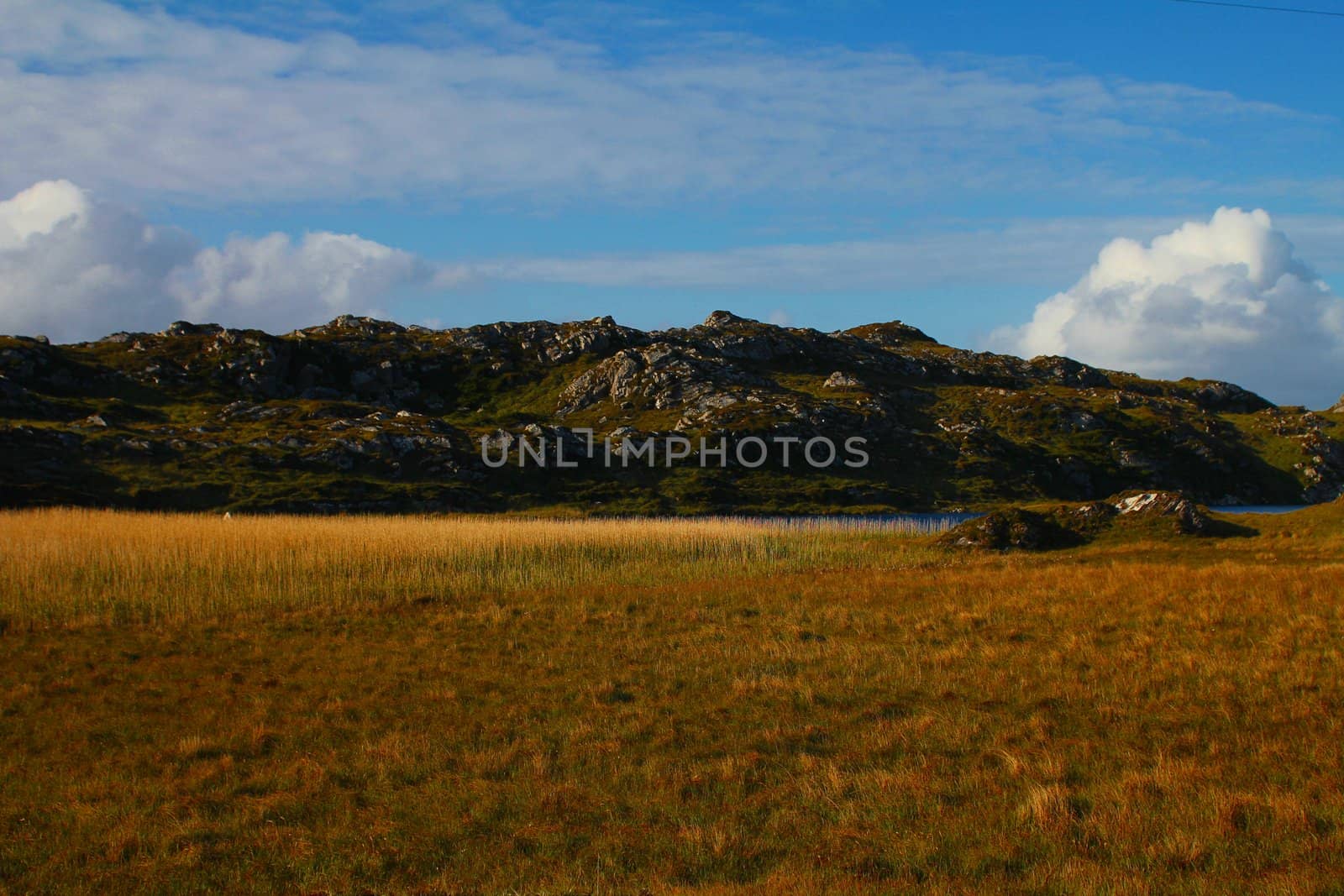 Dry field and rocky hills on Irish peninsula

