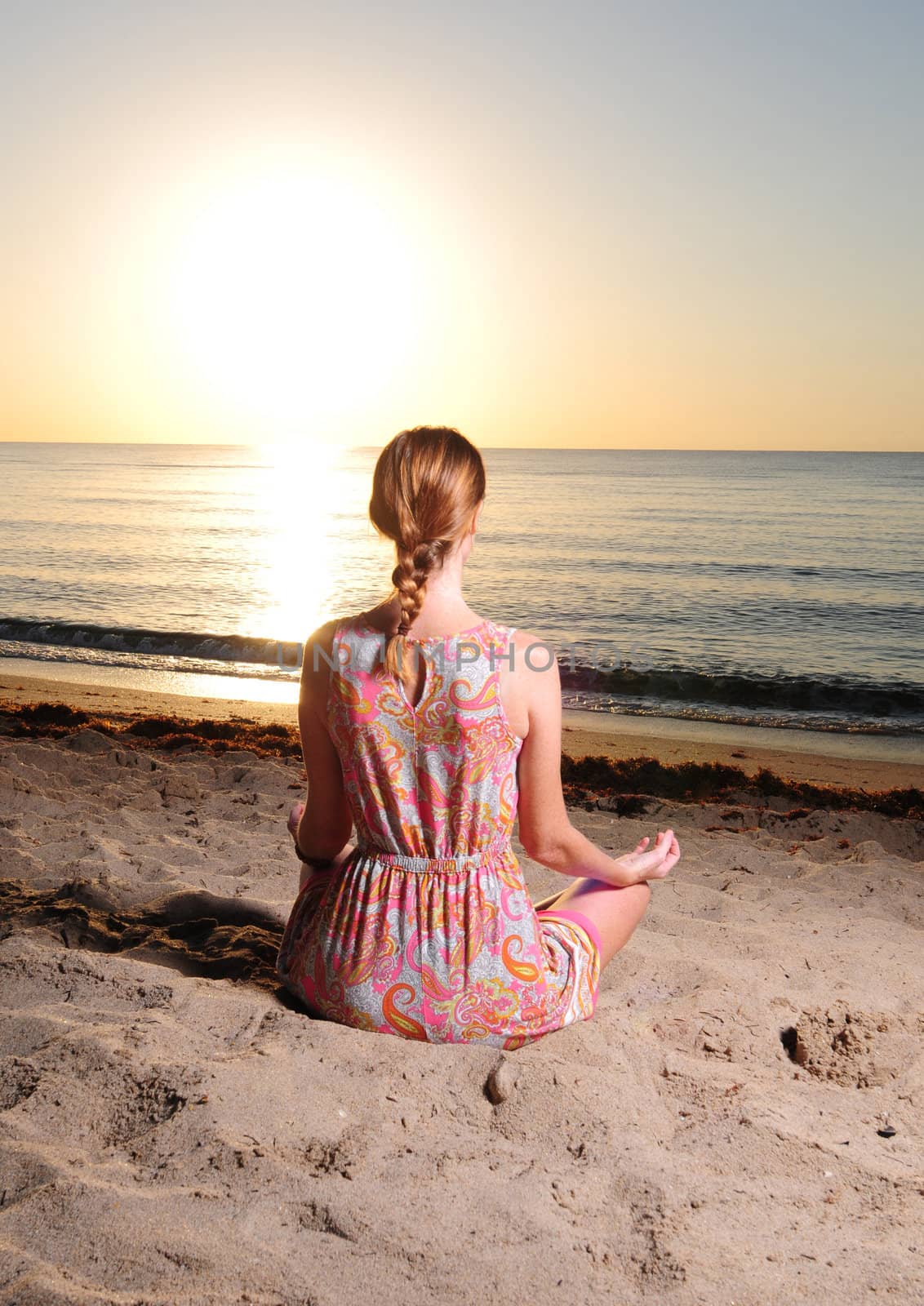 Woman meditating at sunrise by ftlaudgirl