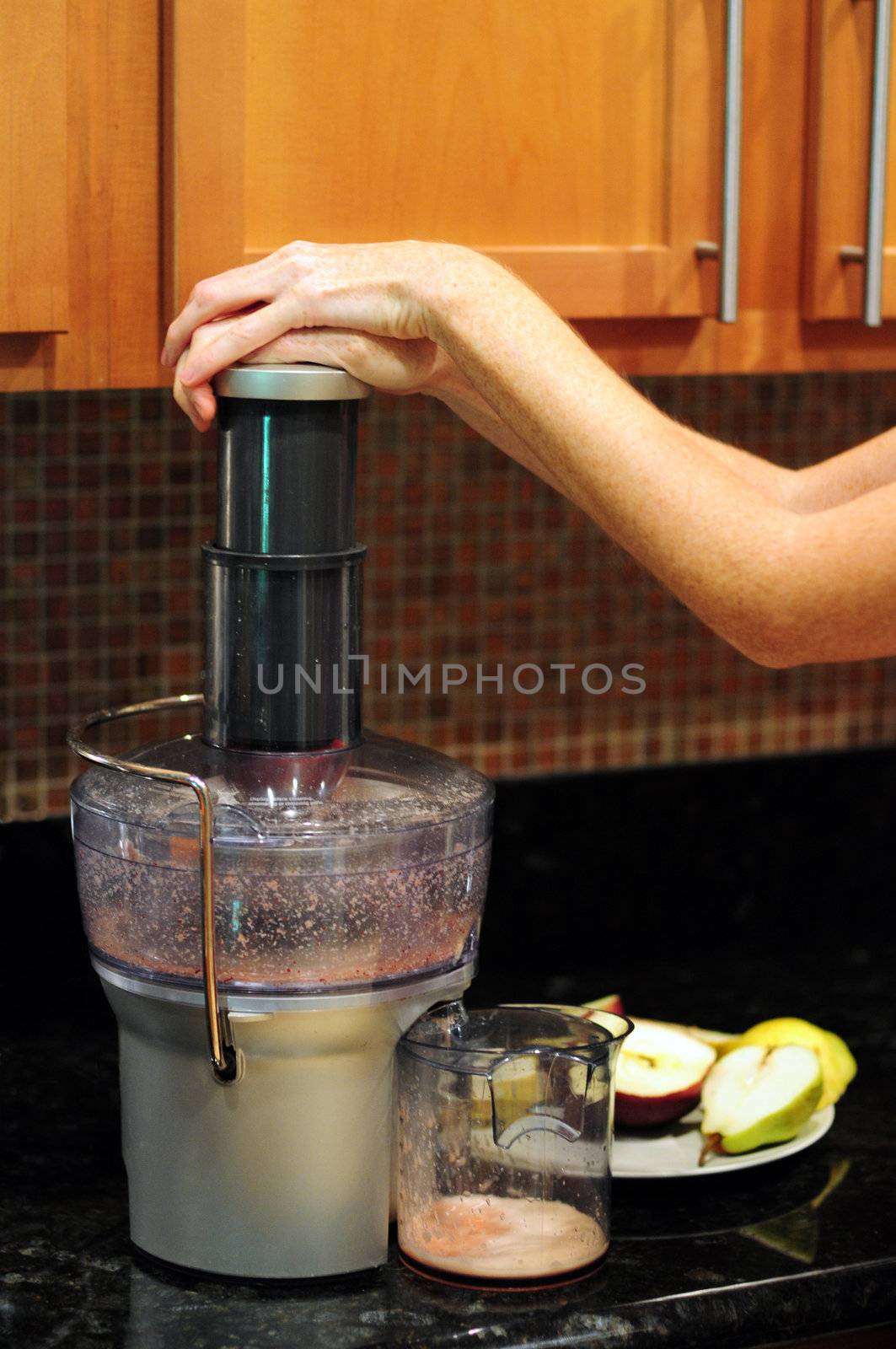 Woman Making apple and pear fruit juice in juicer