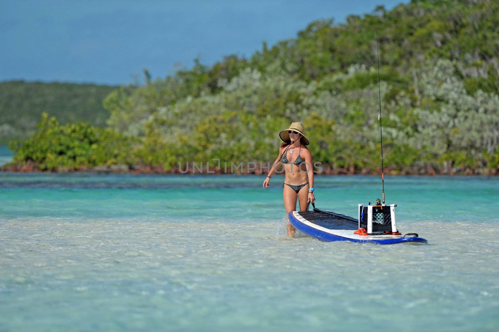 Woman pulling paddle board out to sea by ftlaudgirl