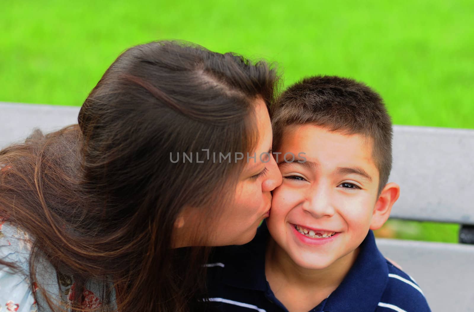 Loving mother kissing her attractive young son on the cheek