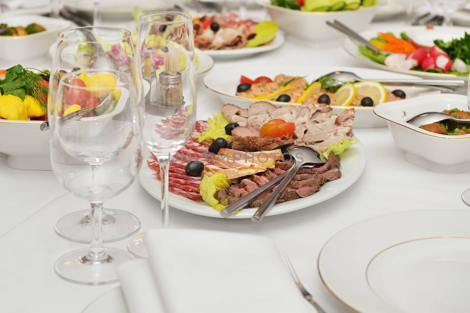 Served table with appetizers, dishes and glasses.