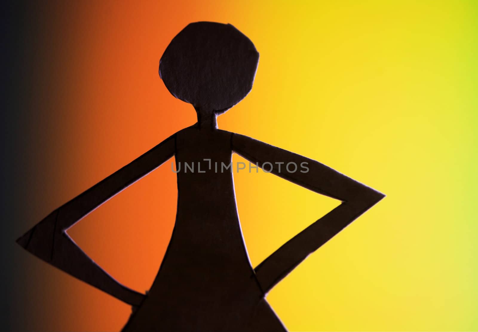 woman silhouette cut in small rudimentary figures  in paper , shot with colorfull background