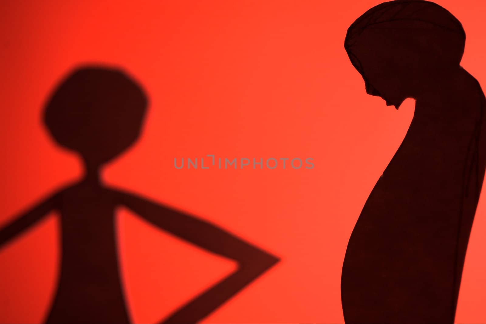 man and woman silhouette cut in small rudimentary figures  in paper , shot with colorfull background