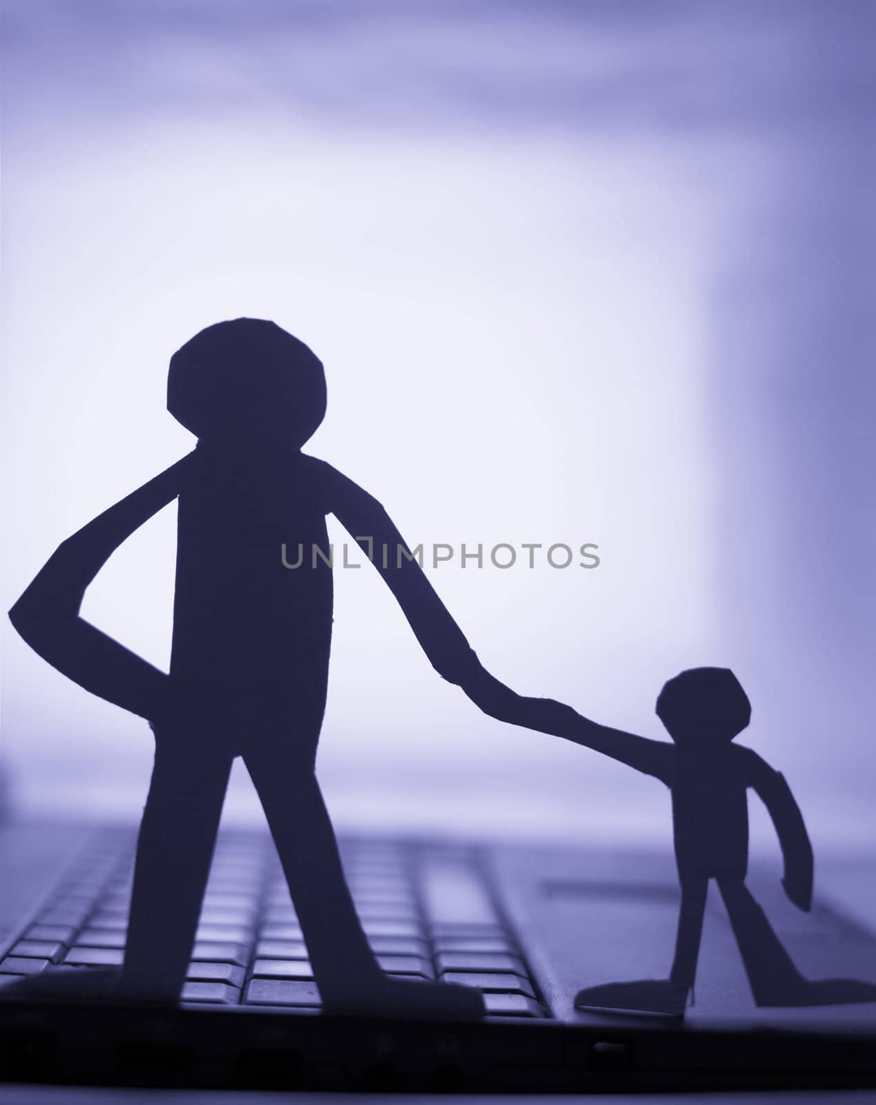father and son  silhouette cut in small rudimentary figures  in paper , man holding child hand facing a computer

