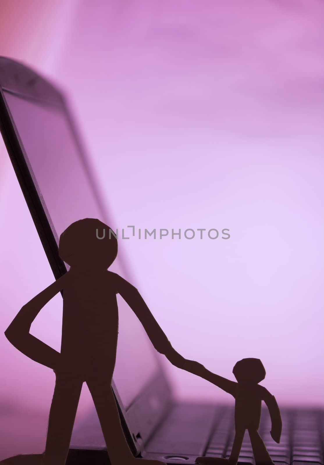 father and son  silhouette cut in small rudimentary figures  in paper , man holding child hand facing a computer

