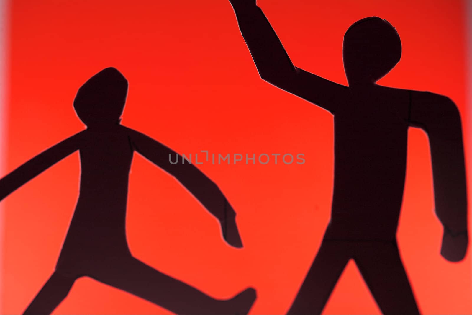 people silhouette cut in small rudimentary figures  in paper , shot with colorfull background