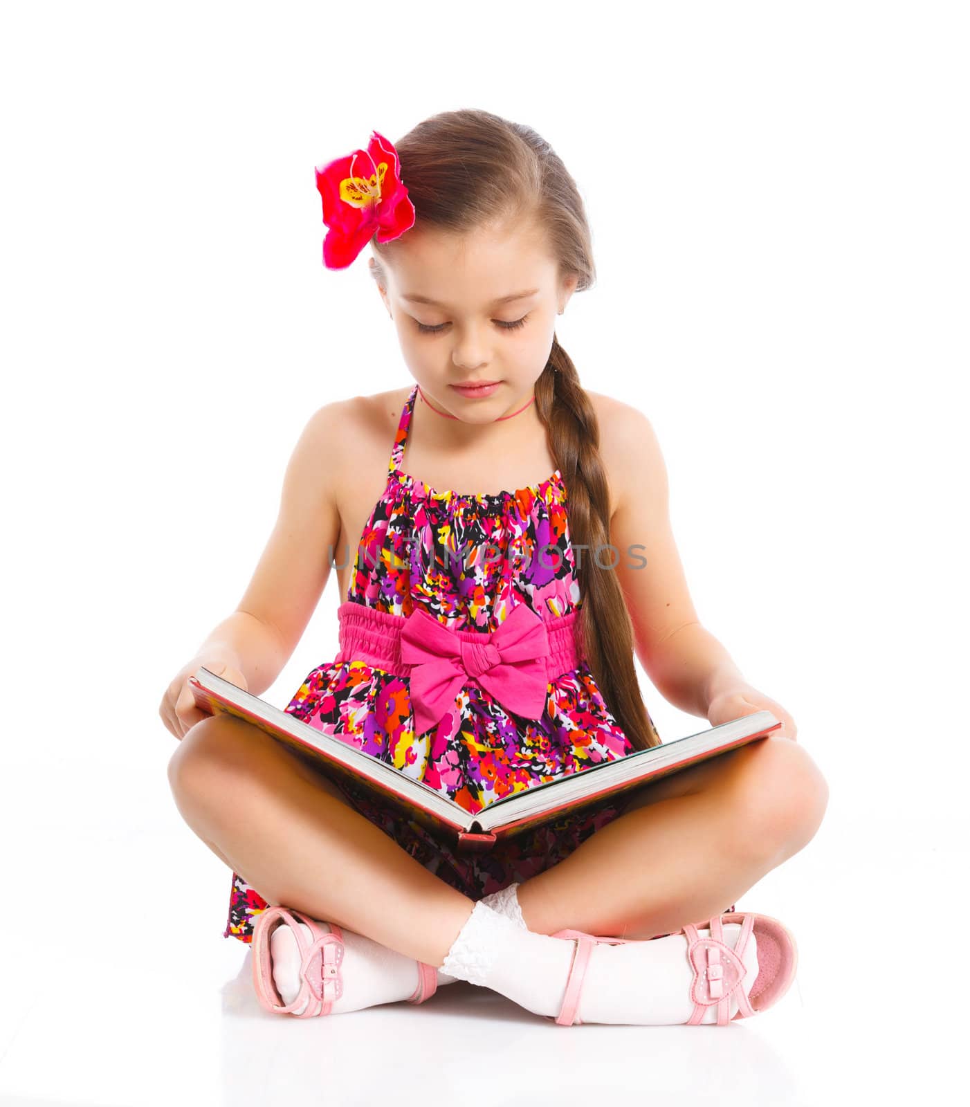 Happy cute girl sitting with book, isolated over white
