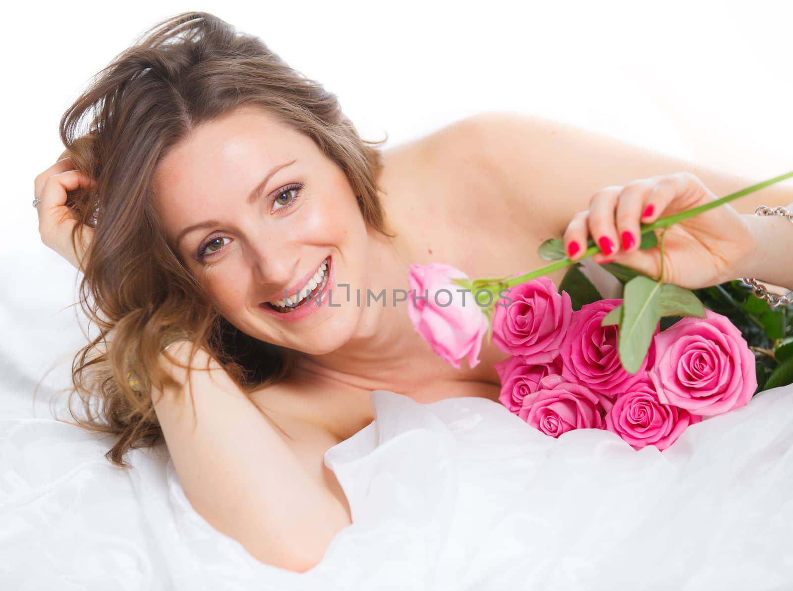Beautiful young woman smelling a bunch of fresh roses