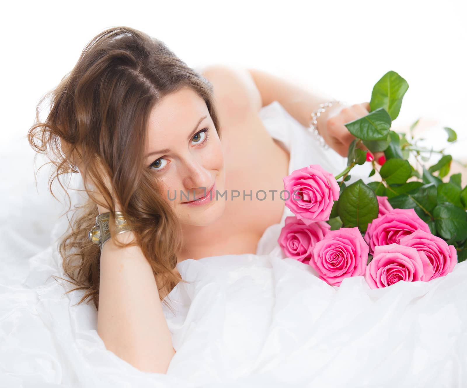 Beautiful young woman smelling a bunch of fresh roses