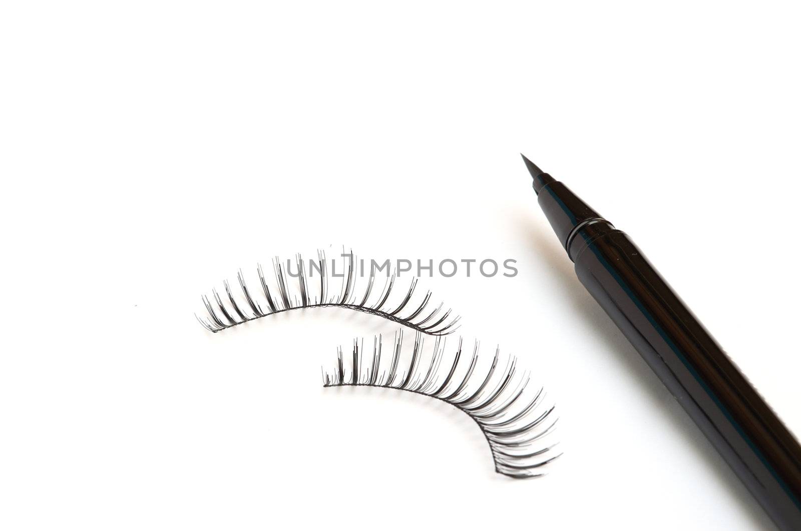 False eyelashes and eyeliner on white background