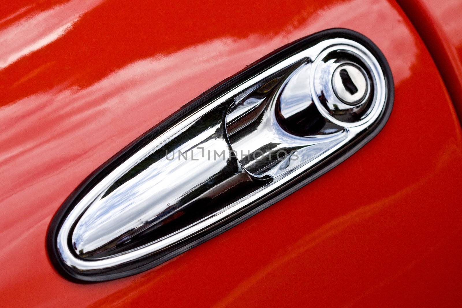 Closeup on door handle of red retro car